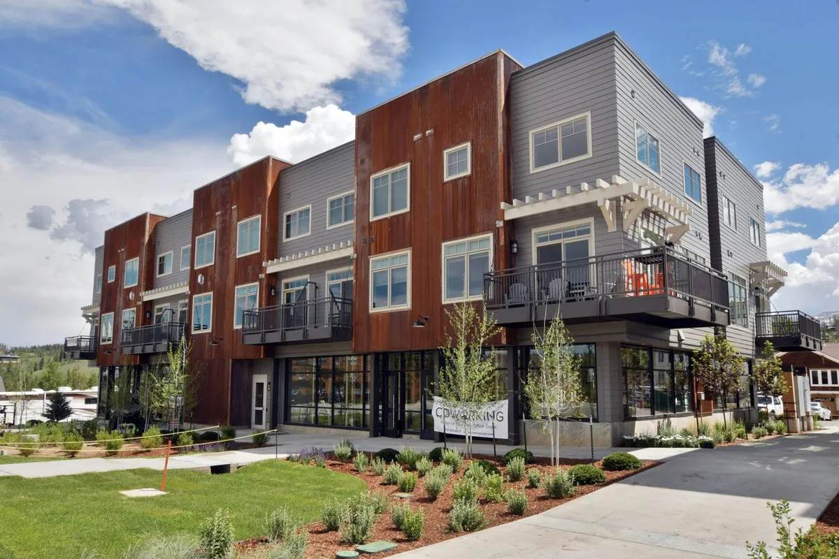 A sunny exterior view of a modern residential building with large windows and inviting balconies. The scene suggests a vibrant community, with hints of social gatherings, outdoor dining, and possibly sunset views from the balconies, tying in the idea of enjoying time with loved ones at home.