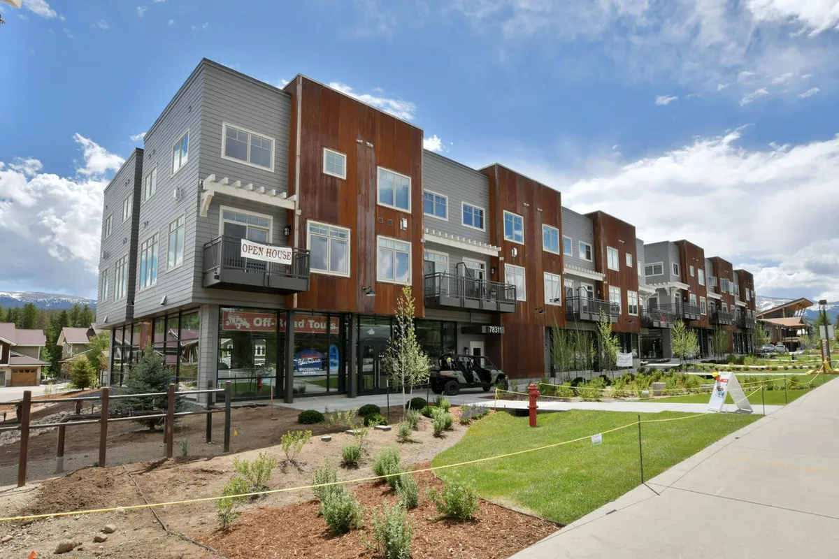 A contemporary exterior shot of the property, featuring modern architecture and balconies. The setting is lively and welcoming, inviting visitors to enjoy the scenic surroundings and participate in community events.